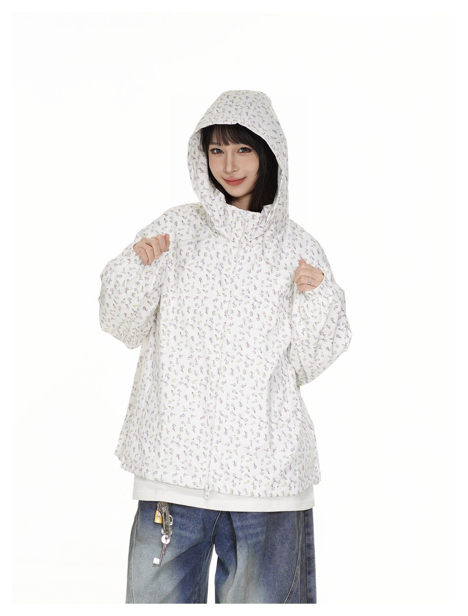 Closer view of a model wearing a zipped white floral-print hooded jacket with the hood up.