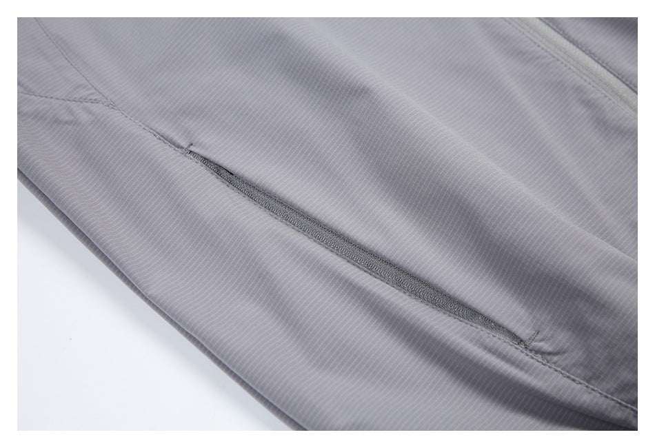 Close-up of a narrow zippered pocket on the light gray jacket, with fine vertical stripes and seam details.