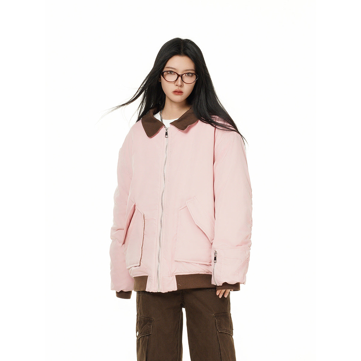Model wearing an oversized pale pink zip jacket with a dark brown collar and cuffs, paired with brown cargo pants.