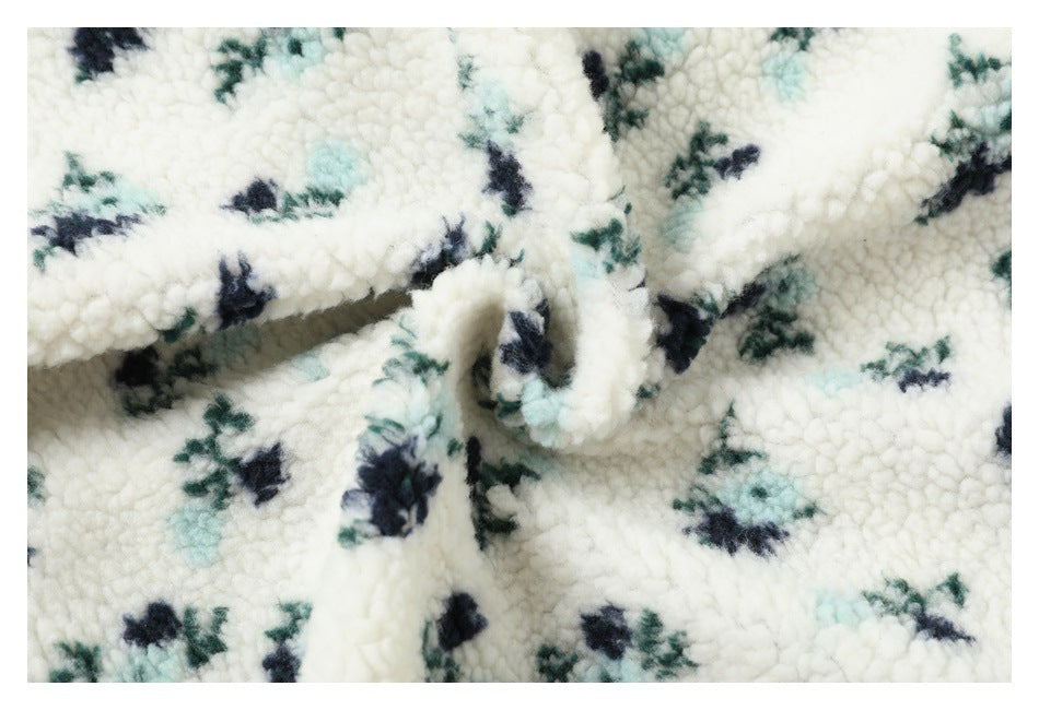 Close-up of gathered ivory plush fabric patterned with small navy, teal, and pale aqua flowers.