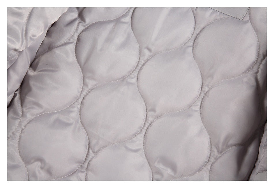 Close-up of the light gray jacket’s interior with curved quilted stitching.