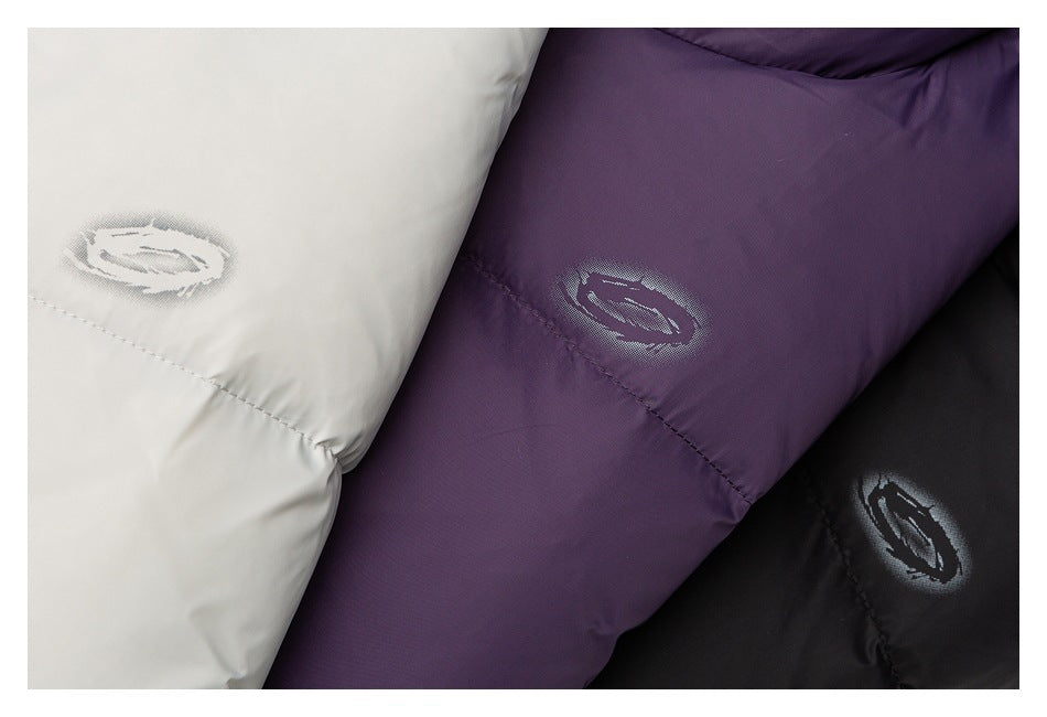 Close-up of oval jacket emblems on white, deep purple, and black quilted fabric.