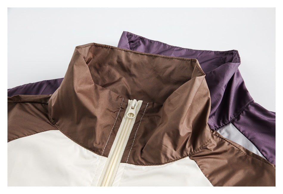 Close-up of two colorways showing tall collars, cream front zippers, and contrasting jacket panels.