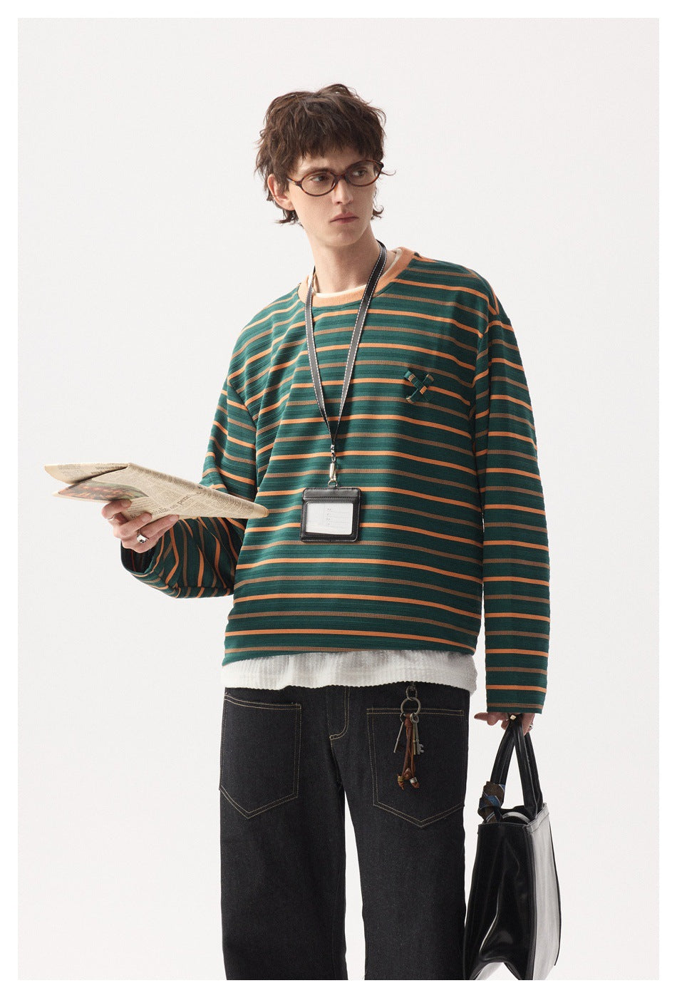 Closer view of a model wearing a green and orange striped long-sleeve shirt with a small chest detail.