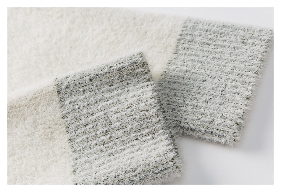 Close-up of a gray ribbed cardigan cuff against the ivory fuzzy knit body.