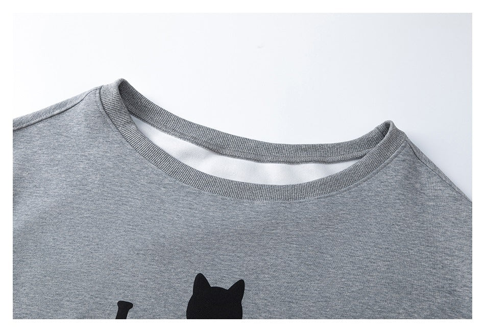 Close-up of a heather-gray sweatshirt's ribbed crew neckline and partial black cat graphic.