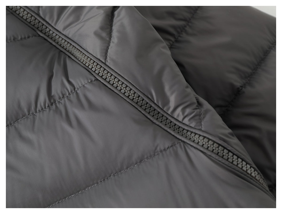 Close-up of a charcoal quilted jacket panel and diagonal zipper.