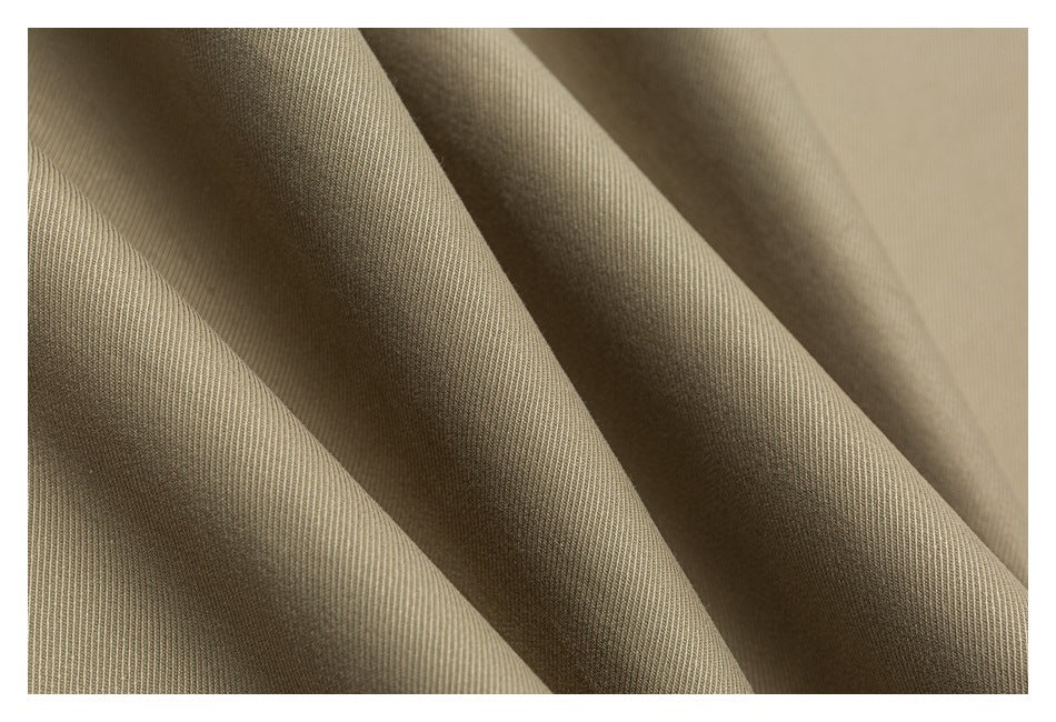 Close-up of beige fabric draped in folds, showing its fine diagonal weave.