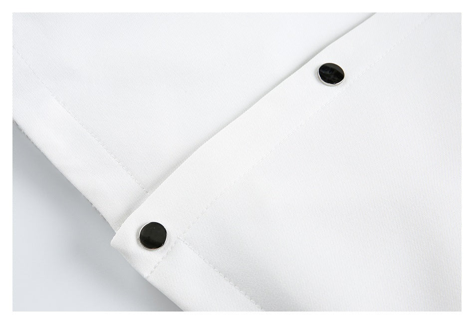Close-up of white garment fabric with two black snap buttons along a stitched edge.