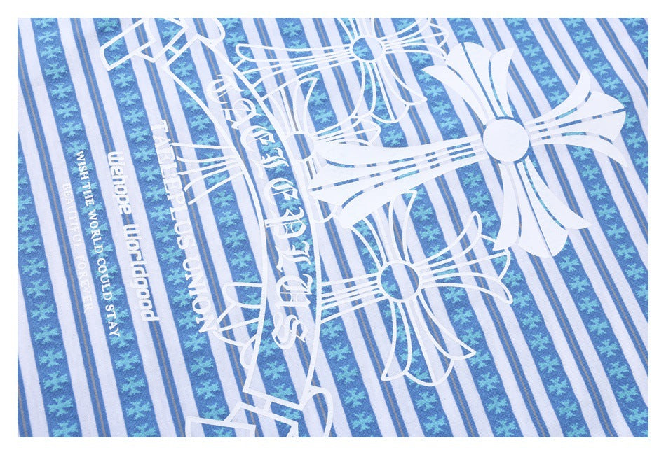 Close-up of a blue-and-white striped shirt with large white graphic lettering and ornamental motifs.