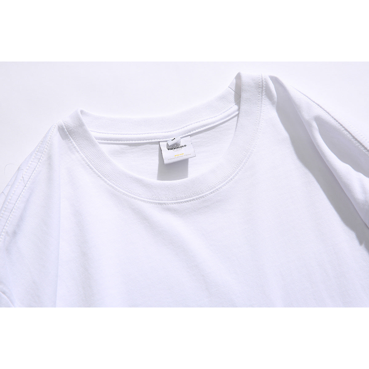 Close-up of a white T-shirt's ribbed crew neck and sewn inner label.