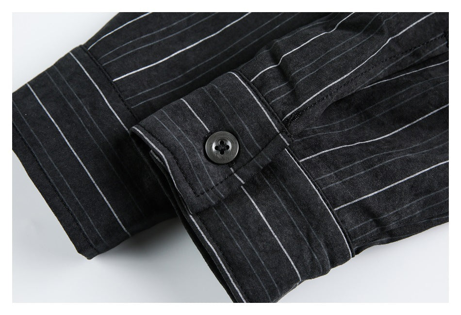 Close-up of a black garment cuff with thin white pinstripes and a dark button.