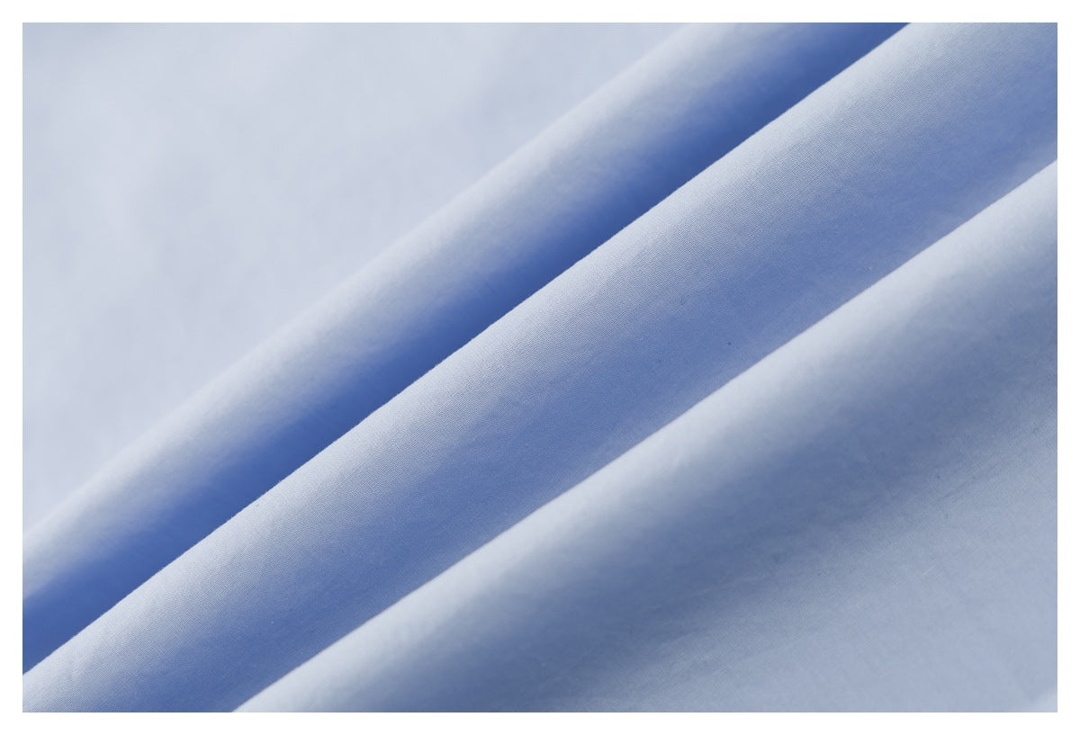 Close-up of pale blue shirt fabric draped in soft folds.