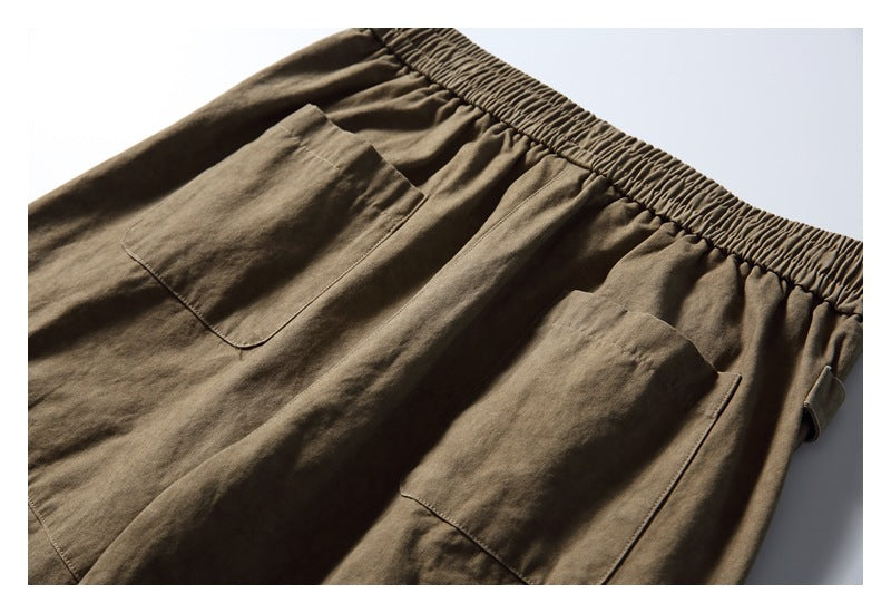 Close-up of olive-brown elastic-waist bottoms with two large patch pockets.
