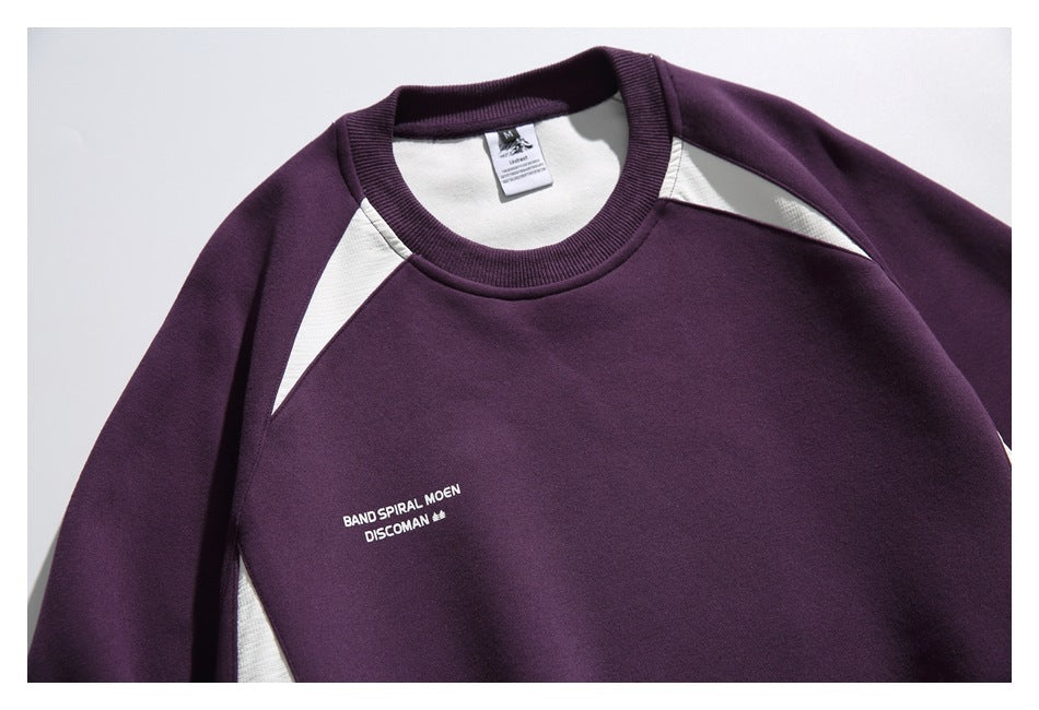 Dark plum crewneck sweatshirt with white triangular shoulder inserts and small white English chest print, shown from the