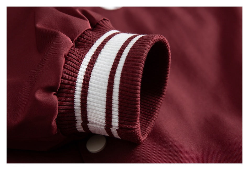 Close-up of a burgundy jacket cuff with burgundy-and-white stripes and a visible snap button.