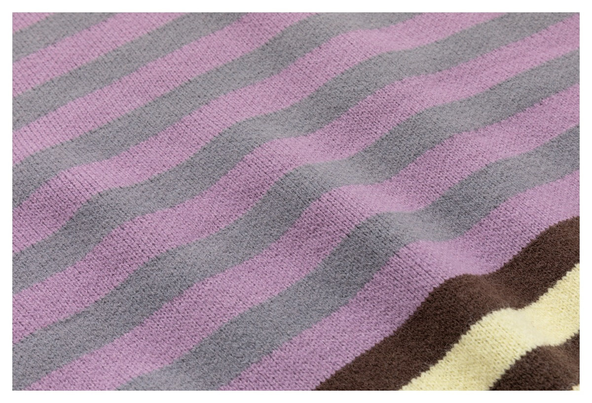 Close-up of pink and blue-gray wavy stripes on a knit garment, with a brown and cream section at the edge.