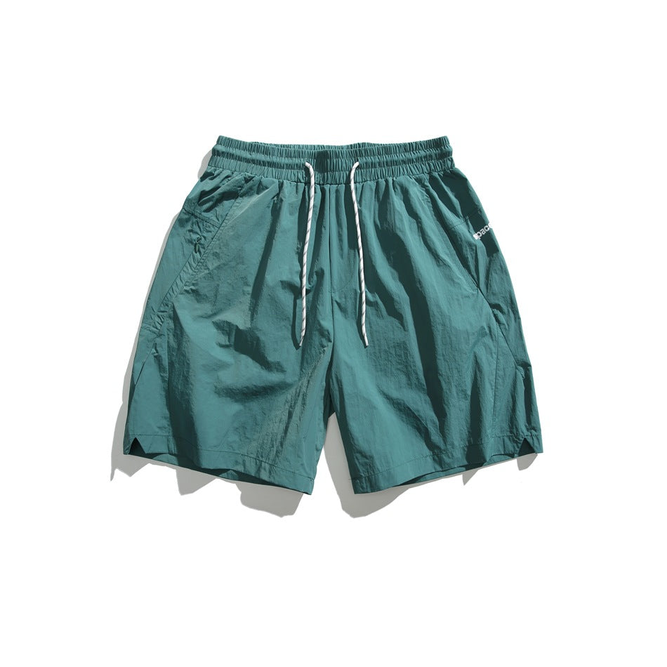 Green drawstring shorts with white cord, flat lay front view