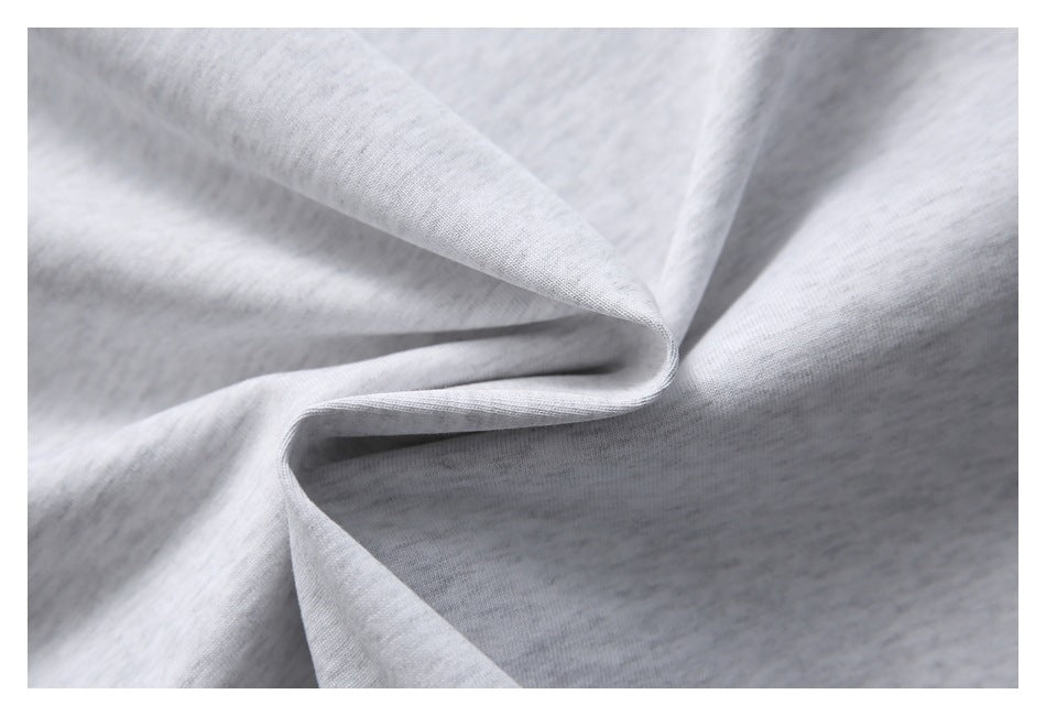 Close-up of light gray heathered fabric folded into soft folds.