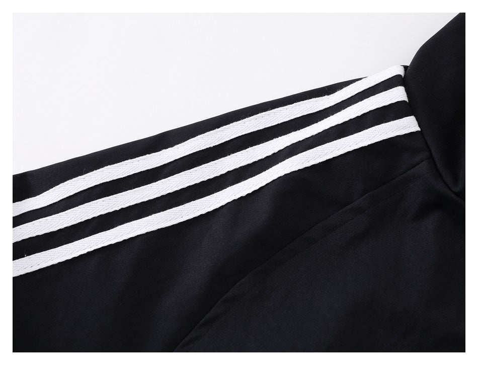 Close-up of three white stripes along the black jacket sleeve.