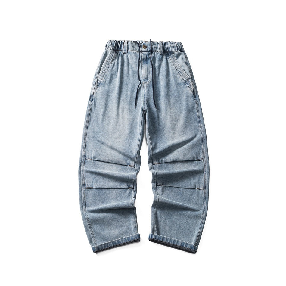 Light-blue washed wide-leg jeans flat lay with elastic waist, drawstring, knee pleats and cuffed hems