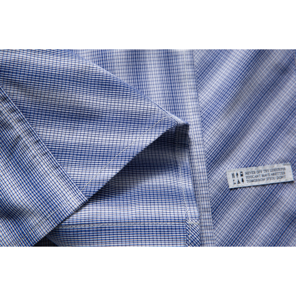 Close-up of the blue-and-white check shirt fabric and a small sewn label inside the garment.