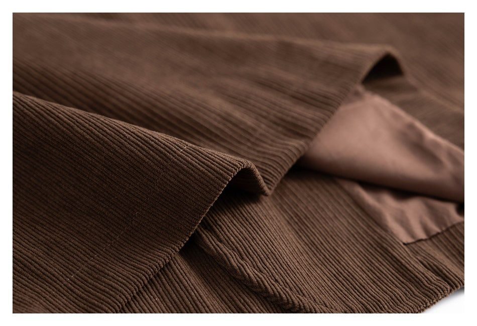 Close-up of brown corduroy fabric folded back to show a smooth brown lining.