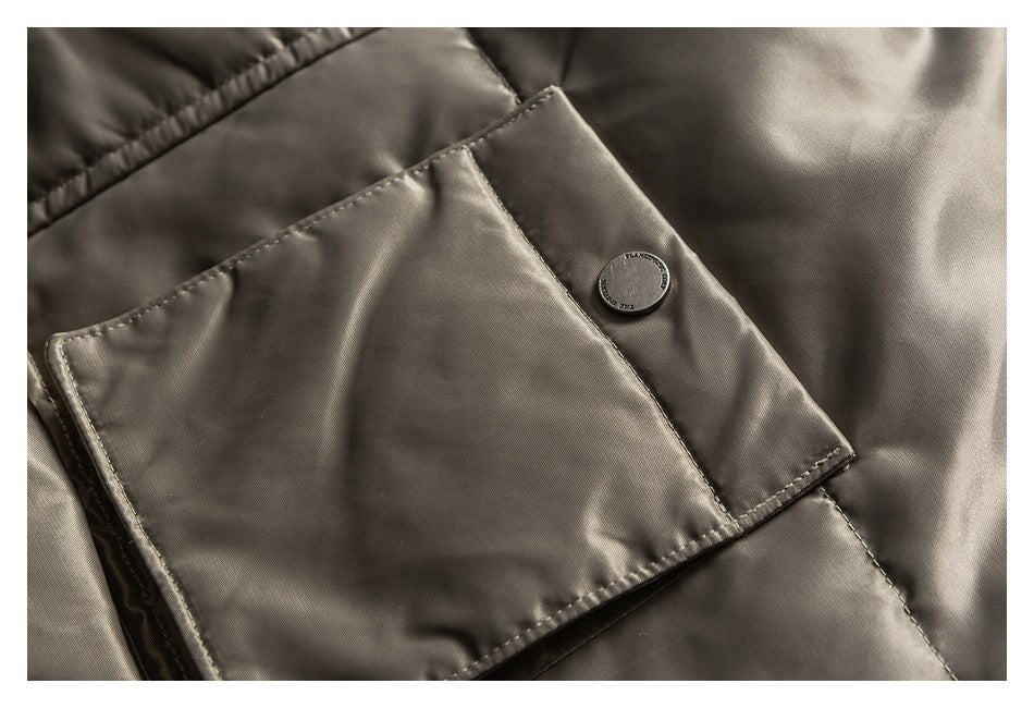 Close-up of a taupe jacket's large flap pocket and snap-button tab.