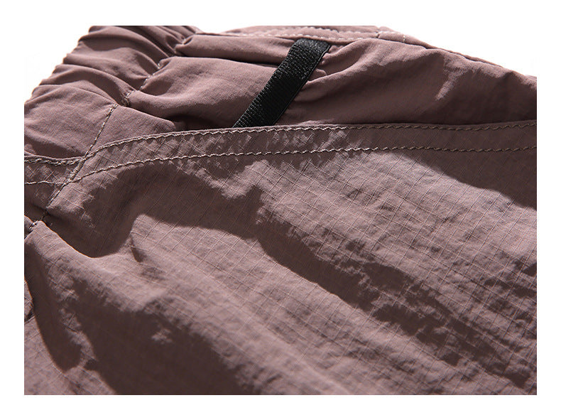 Close-up of mauve pants showing fabric texture, waistband stitching, and a black loop.