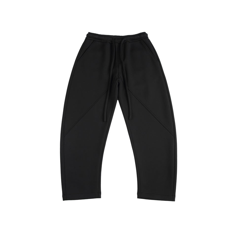 Black drawstring sweatpants with slanted pockets and diagonal front seams, flat lay, front view