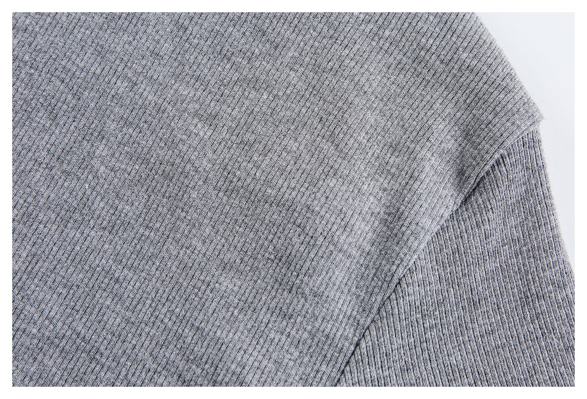 Close-up of the gray rib-knit garment shoulder and sleeve seam.