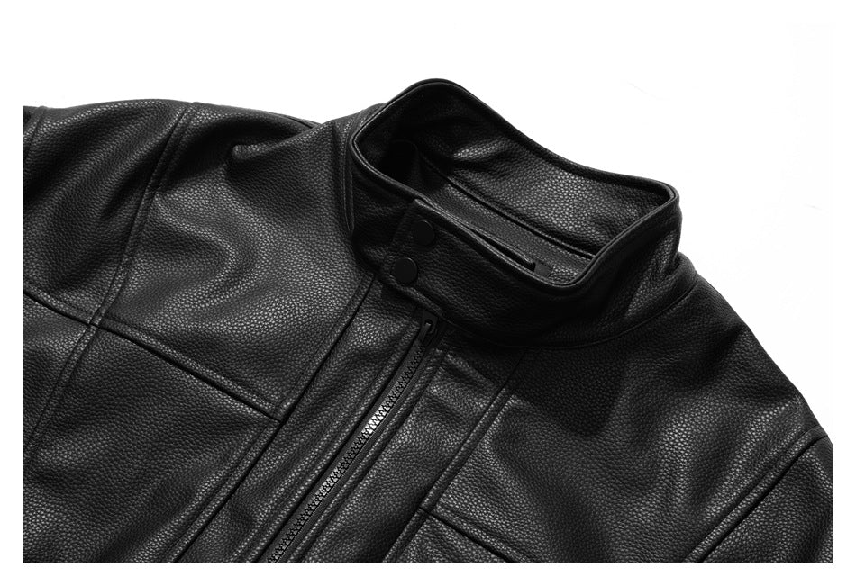 Cropped front view of a black pebbled jacket with a snap-tab stand collar and central zipper.