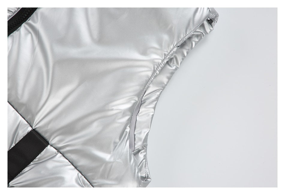 Close-up of the curved armhole and side seam on shiny silver sleeveless outerwear.