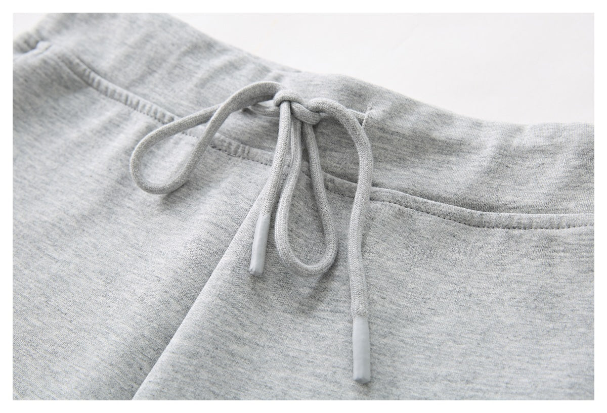 Close-up of the gray shorts’ waistband with a tied drawstring and finished tips.