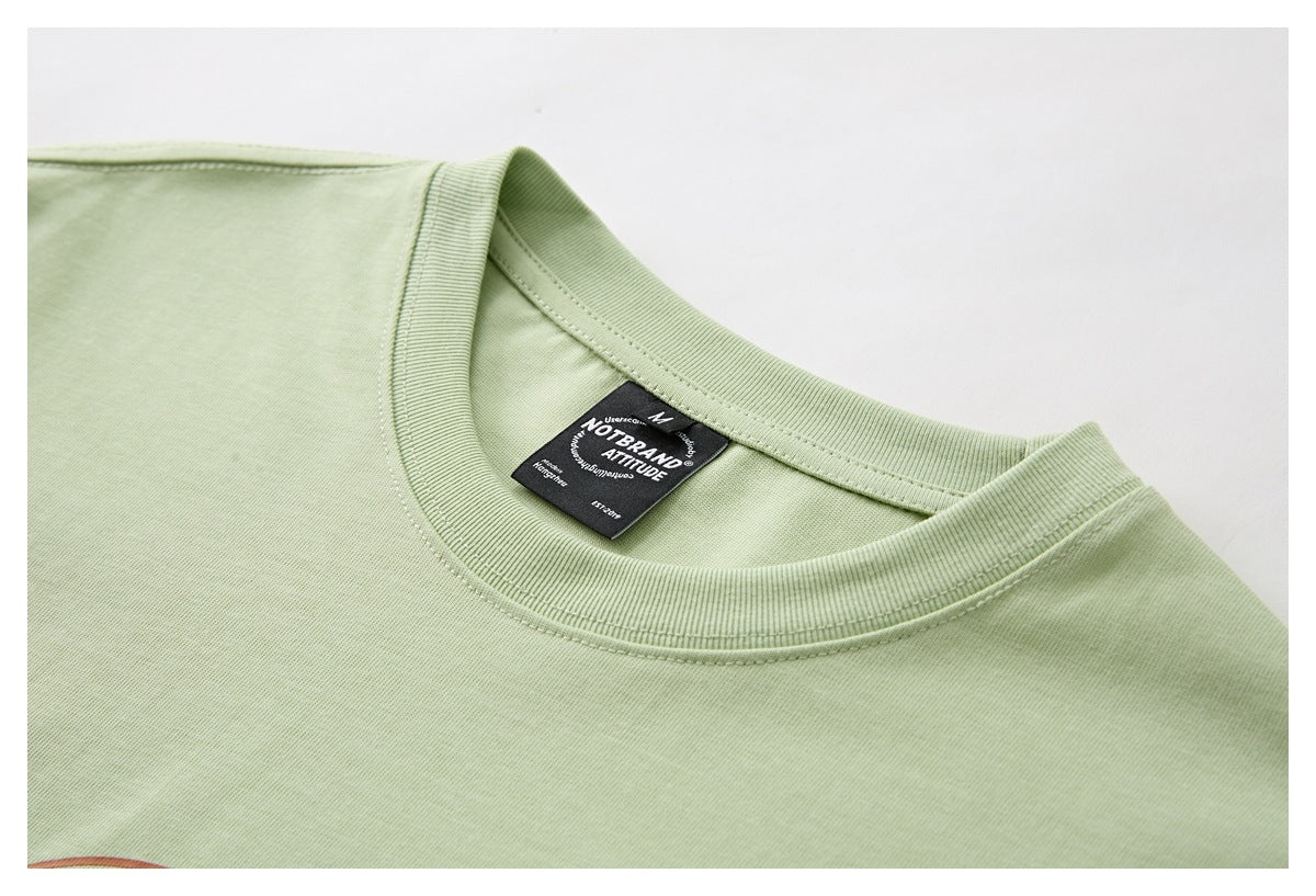 Close-up of a pale green T-shirt neckline with ribbed trim and a black inner label.