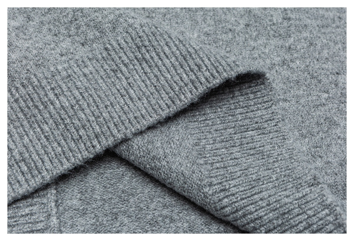 Close-up of a gray knitted sleeve cuff folded over the sweater body.