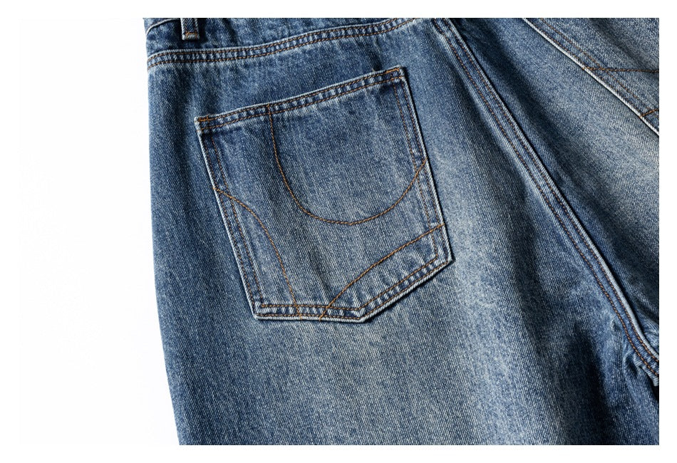 Close-up of a back pocket on blue jeans with contrasting brown stitching.