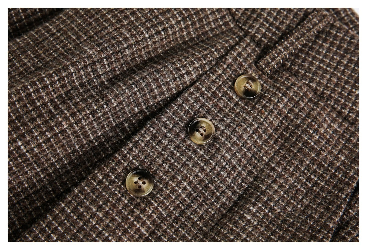 Close-up detail of brown small-check fabric and three brass-tone buttons.