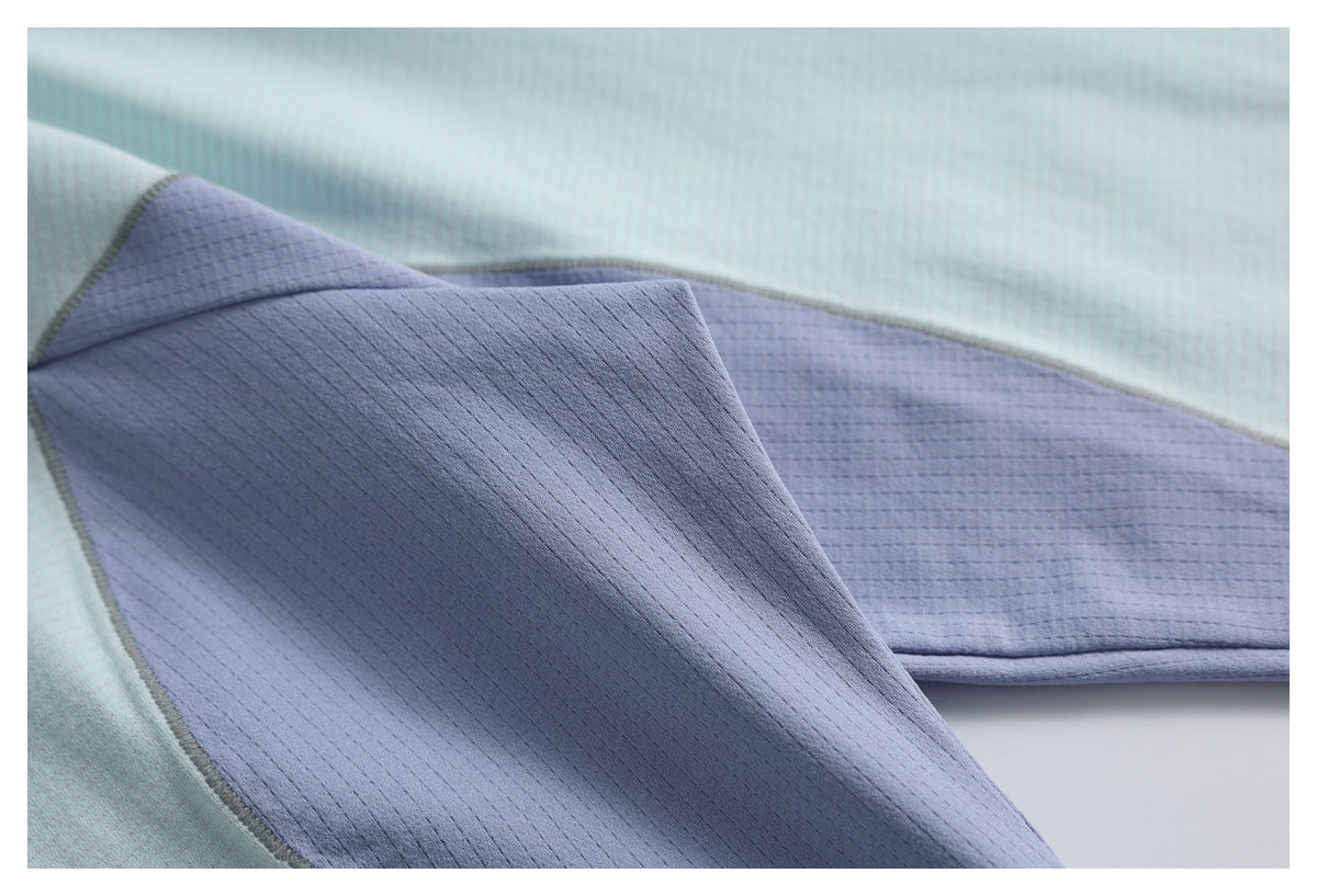 Close-up of a lavender panel joined to pale aqua fabric, showing the textured surfaces and stitched seam.