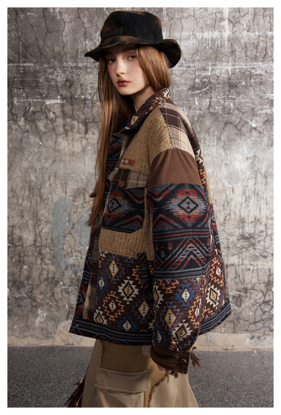 Side view of a model wearing a patterned patchwork jacket with tan and brown panels.