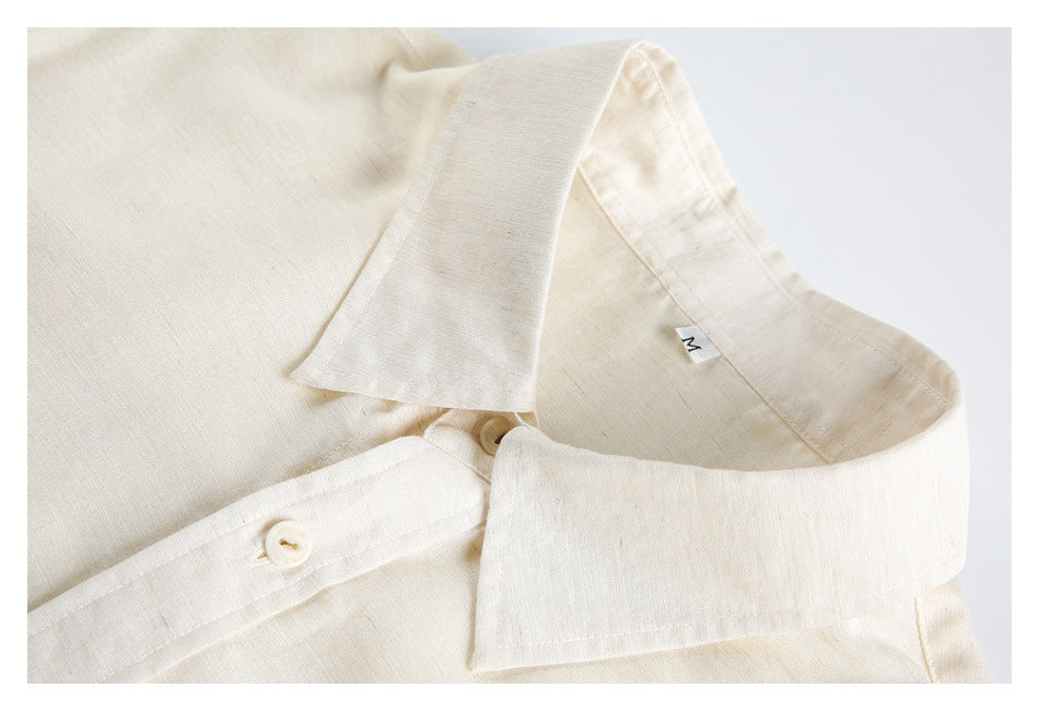 Close-up of an ivory shirt's pointed collar, button placket, and inner size tag.