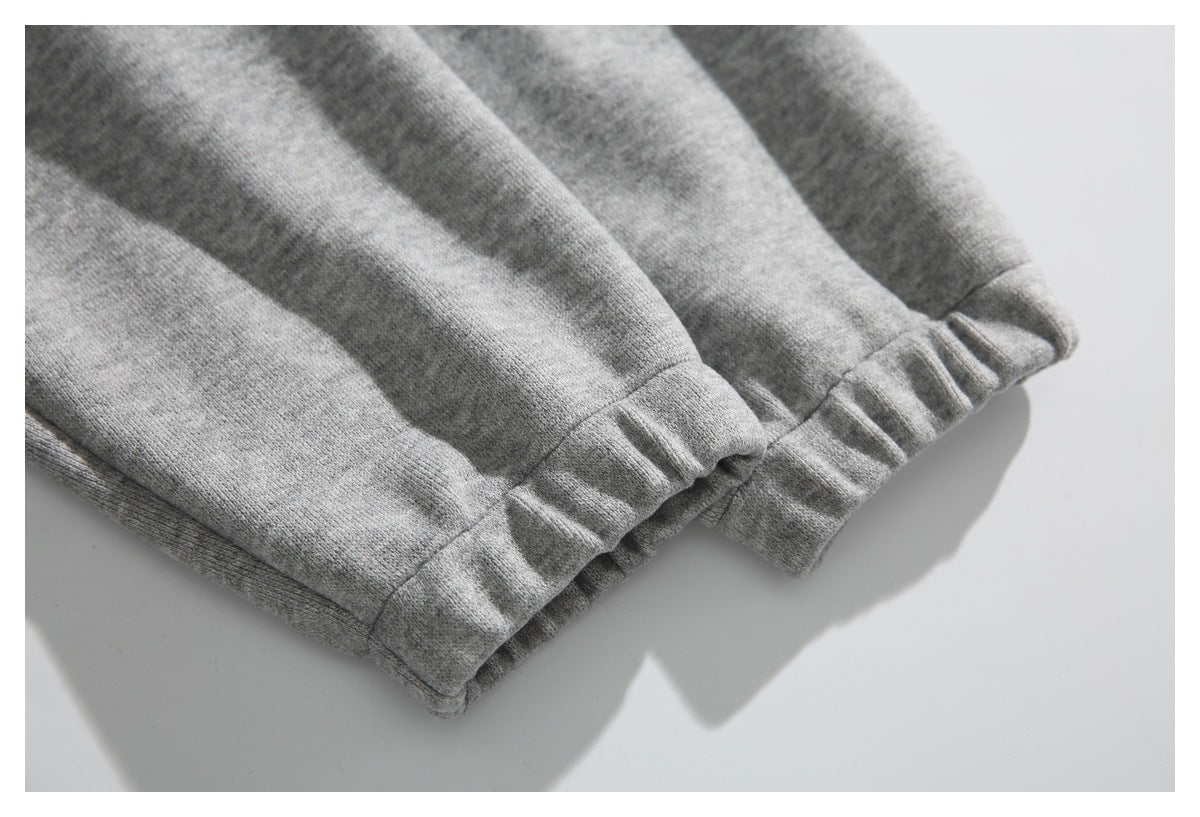Close-up of a gathered elastic cuff on heather gray knit fabric.