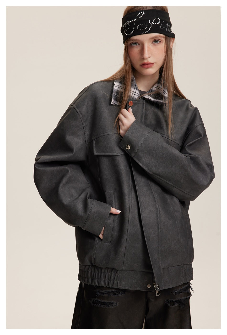 Model wearing a charcoal jacket with a plaid collar, front zipper, flap chest pockets and gathered hem.