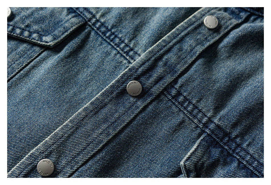 Close-up of a washed blue denim button placket with metal buttons and contrast stitching.
