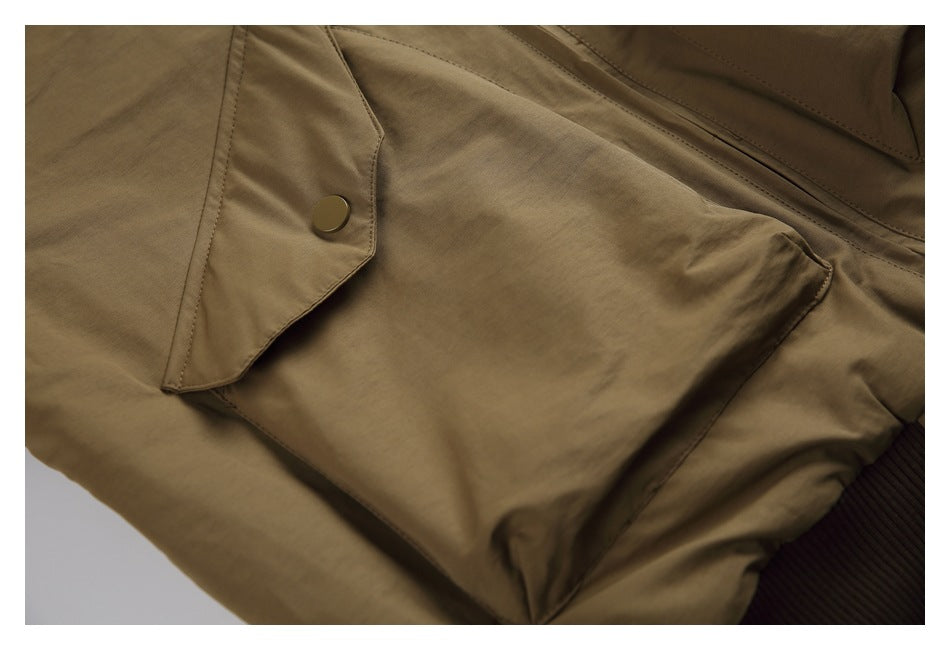 Close-up of an olive-brown jacket flap pocket with a snap button and visible stitching.