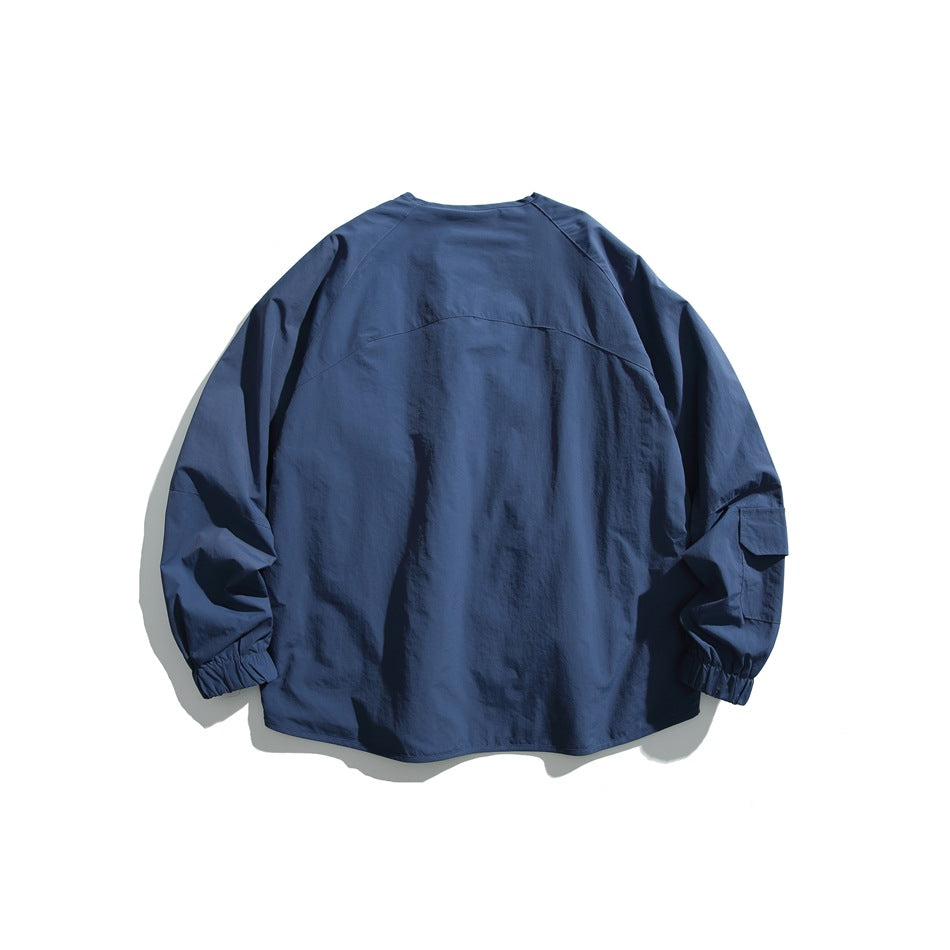 Back view of a navy jacket with a curved yoke seam, raglan sleeves, and elastic cuffs.