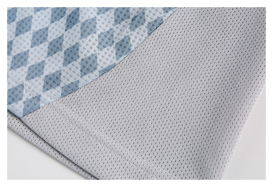 Close-up of the jersey's pale perforated mesh panel, hem stitching, and blue patterned fabric.