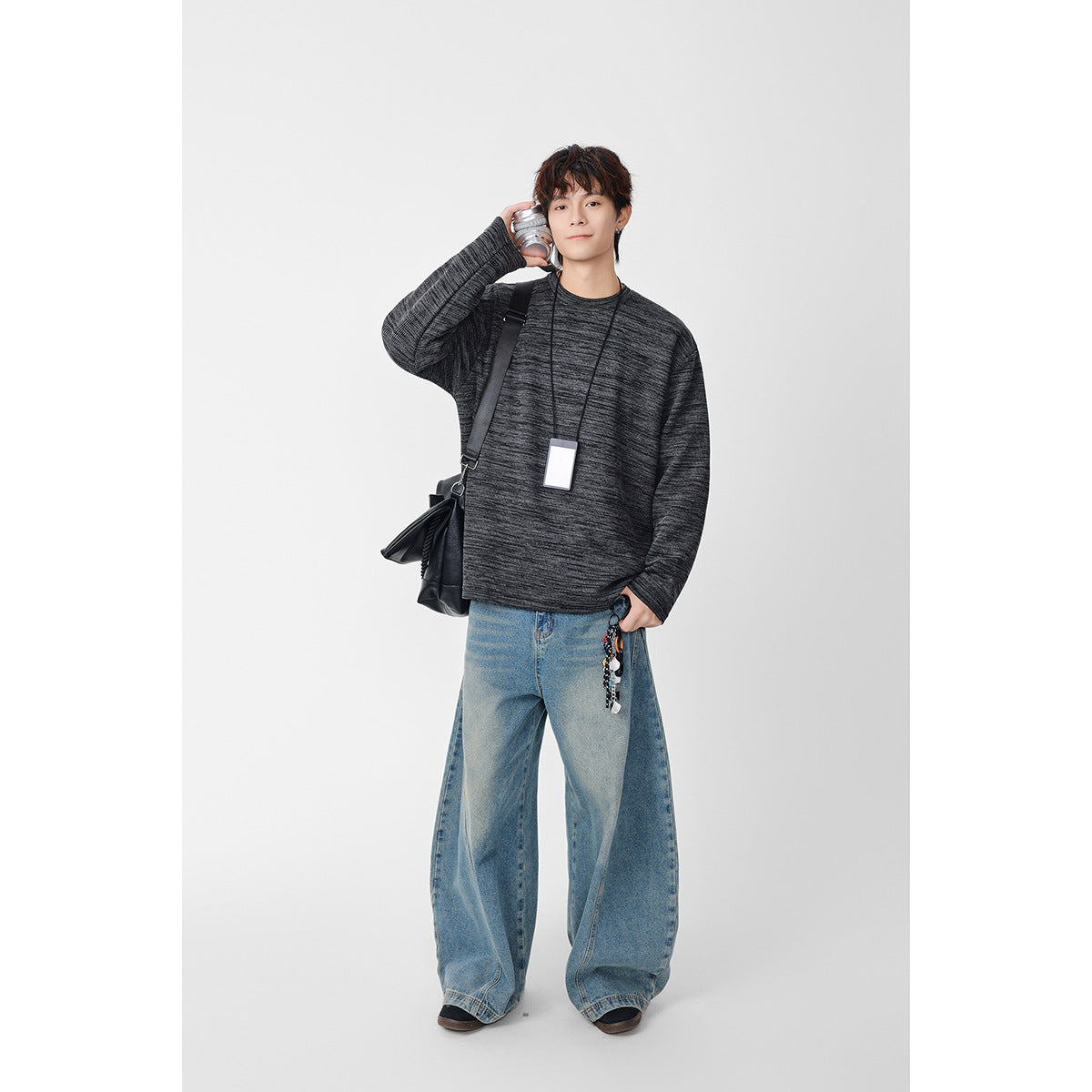 Model wearing a charcoal marled crewneck sweatshirt with long sleeves and a relaxed fit.