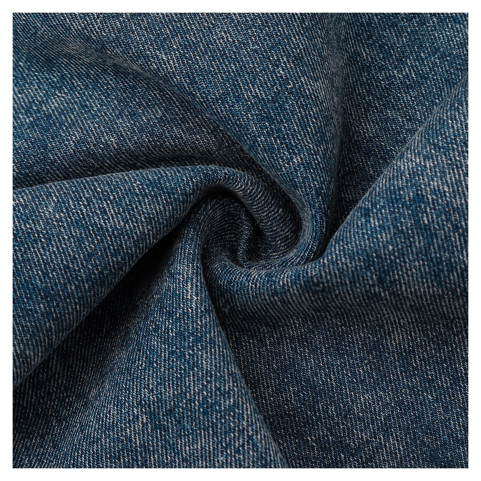 Close-up of dark blue twill fabric gathered into folds, showing its woven texture.