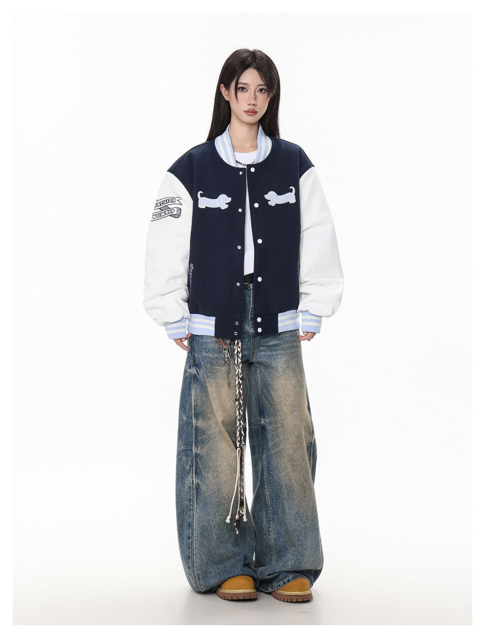 Model wearing an open navy and white varsity jacket with light blue striped trim, white top and wide-leg jeans